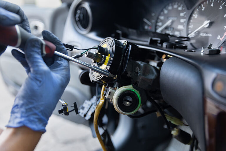 Technician inspecting steering column airbag and wiring components