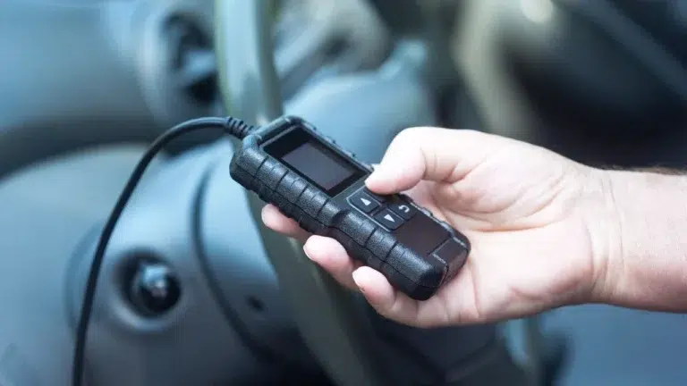 Technician using a diagnostic scanner to identify a BMW engine in Malaysia via the OBD system.