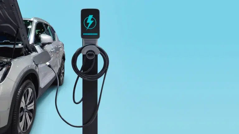 A silver plug-in hybrid BMW car with an open hood connected to an electric charging station, representing essential maintenance and bmw car repair.