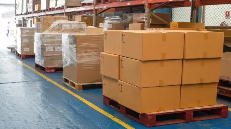 Stacked cardboard boxes of Toyota parts stored on pallets inside a supply warehouse in Malaysia.