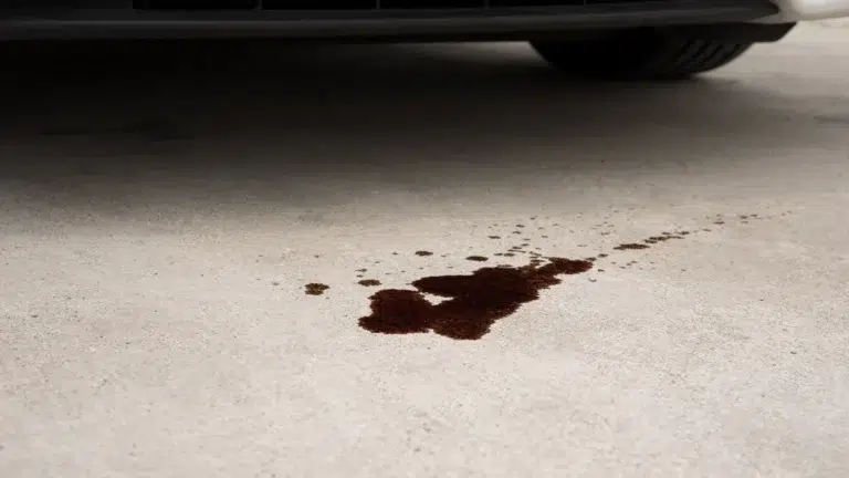 Engine oil stain on a concrete driveway indicating need for new BMW spare parts.