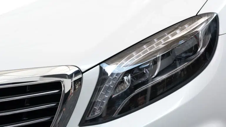 Close-up of a brand-new white car headlight and front assembly from a BMW auto part supply.