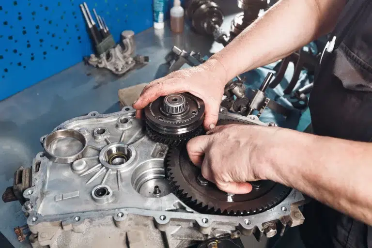 Mechanic inspecting internal gears during a Toyota Vellfire gearbox repair