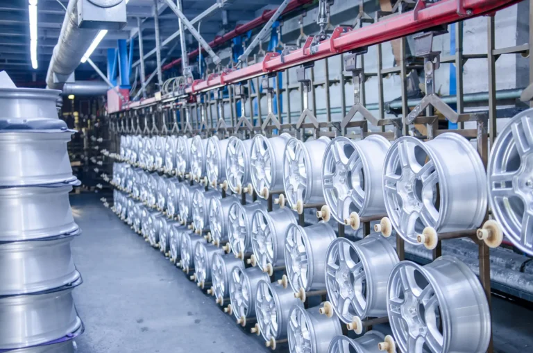 Rows of silver alloy wheels displayed on racks in a BMW spare parts warehouse in Segambut