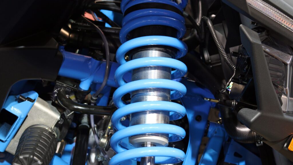 Blue coil spring shock absorber car suspension assembly installed on a vehicle.
